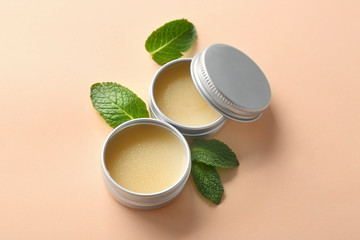 Containers with lemon balm salve and leaves on  light background - obrazy, fototapety, plakaty