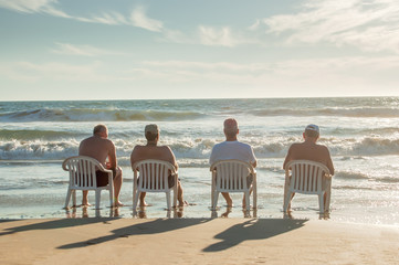 Four men relaxing by the ocean - 166505629