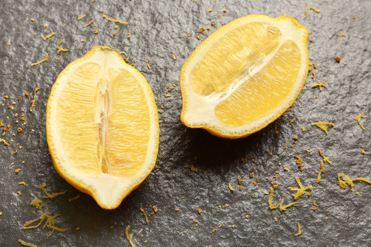 Delicious sliced lemon with zest on dark background