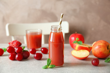 Delicious juice in bottle and fruits on table