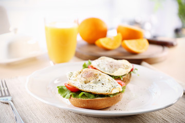 Plate with delicious egg sandwiches on table