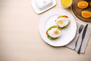Plate with delicious egg sandwiches on light table