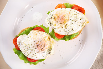Closeup view of plate with delicious egg sandwiches on table