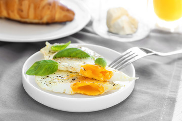 Plate with delicious over hard fried eggs on tablecloth
