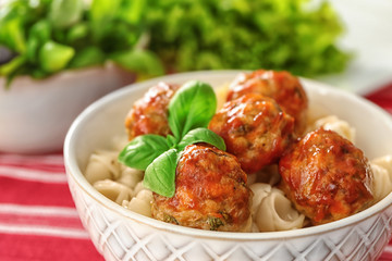Bowl with turkey meatballs and pasta on table, closeup