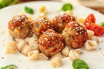 Plate with turkey meatballs and pasta on table, closeup