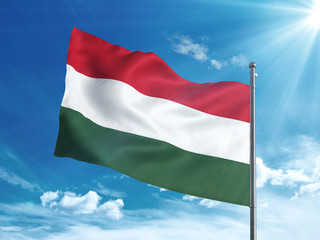 Fototapeta na wymiar Hungary flag waving in the blue sky