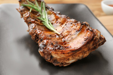 Plate with delicious pork ribs and rosemary, closeup