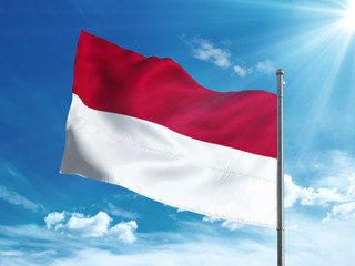 Fototapeta na wymiar Indonesia flag waving in the blue sky