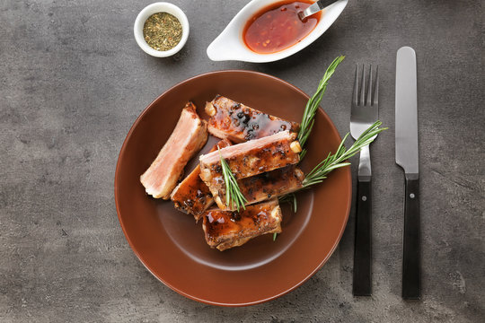 Composition with delicious pork ribs and rosemary on table