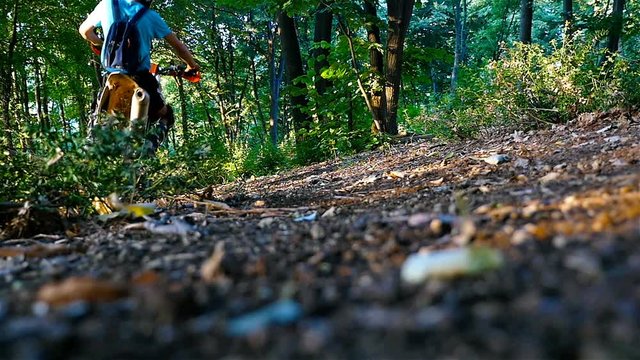 Motocross racer riding in green forest in the mountain, slow motion