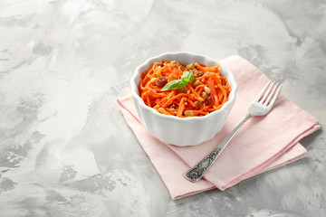 White bowl with delicious carrot raisin salad on grey table
