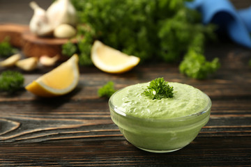 Delicious yogurt sauce in bowl on wooden background