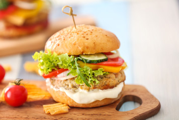 Tasty turkey burger on wooden board