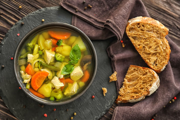 Bowl with delicious turkey soup on slate plate