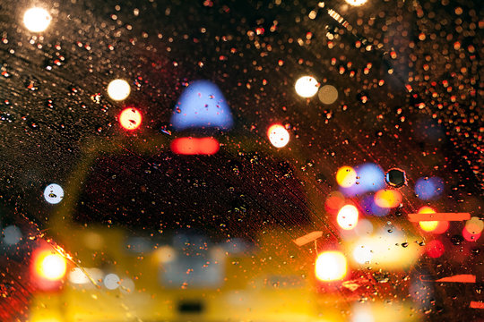 Taxi Cab Through a Wet Car Window in a Rainy Night in New York