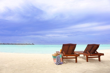 Wooden sun loungers with beach accessories at sea resort