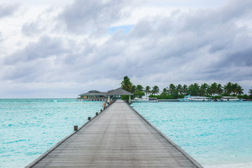 View of tropical resort from wooden pontoon on summer day