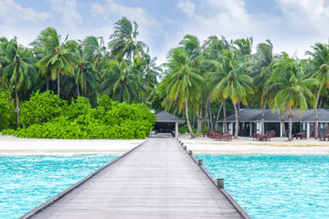 View of tropical beach from wooden pontoon on summer day