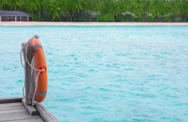 Wooden pontoon with flotation ring at tropical resort on summer day
