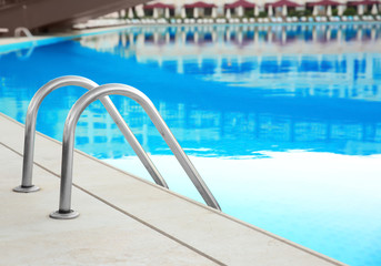 Obraz na płótnie Canvas Modern swimming pool with ladder in luxury hotel