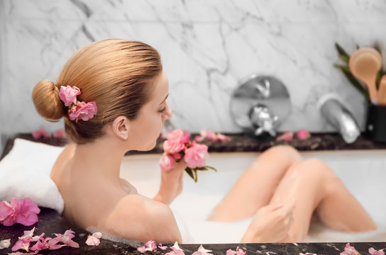Woman relaxing in bath with foam. Spa treatment concept