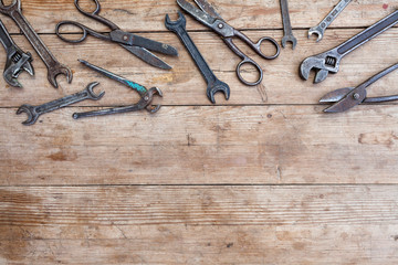 lot of new spare parts and tools on an old battered wooden table.