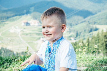 portrait of happy little kid on the peak of tha mountain