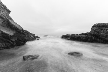 Rocky Malibu beach with motion blur water in Black and White.