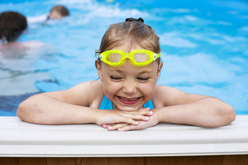 Happy little Girl in bikini swimming pool