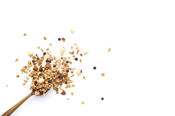 Crumbled granola in a wooden spoon isolated on a white background.  Top view. - obrazy, fototapety, plakaty
