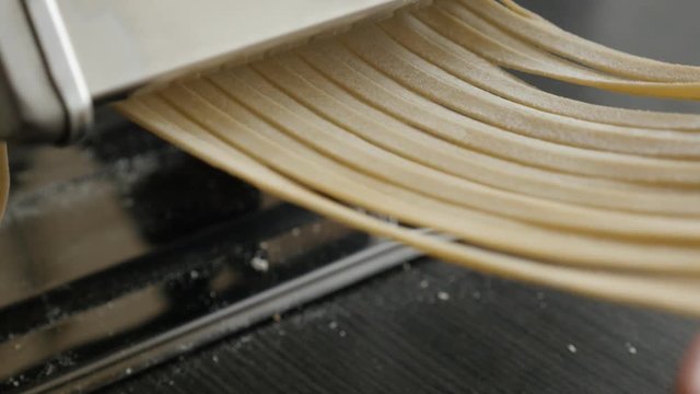 Italian food spaghetti machine close-up 4K 2160p 30fps UltraHD footage - Traditional cylindrical solid pasta made from dough 3840X2160 UHD video 