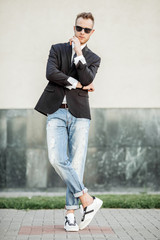 tylish handsome young man with bristle standing outdoors