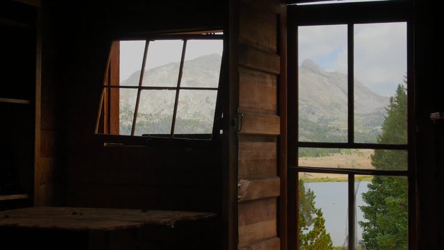 An empty cabin looks out onto a mountain lake in the Wind Rivers Range of Wyoming.