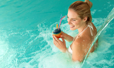 Beautiful woman enjoying jet of water in wellness resort