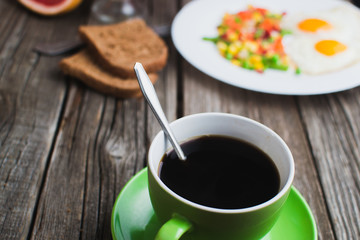 Coffee in a green mug on wooden surface
