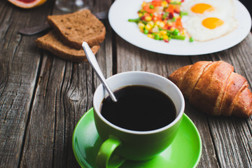 Coffee in a green mug on wooden surface