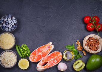 Detox healthy food concept with salmon fish, vegetables, fruits and ingredients for cooking. Selection of healthy and good for heart food. View from above, top studio shot