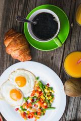 Coffee in a green mug on wooden surface