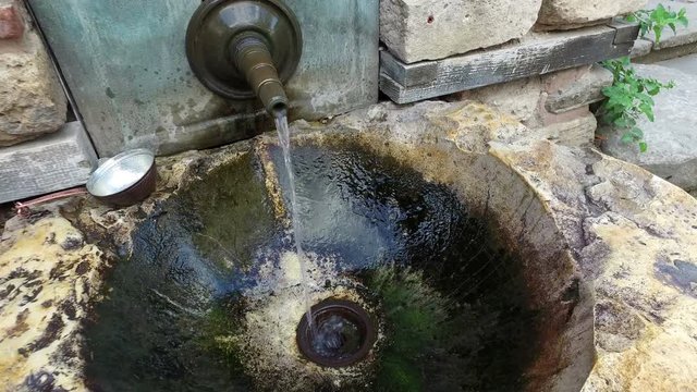 Water flows from An Old Ancient Tap Facet