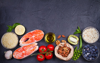 Detox healthy food concept with salmon fish, vegetables, fruits and ingredients for cooking. Selection of healthy and good for heart food. View from above, top studio shot