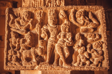 Fine example of Indian art carvings with Shiva Lord and life of ancient people scene on column of 7th century temples in Pattadakal, India. UNESCO World Heritage site.