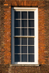 Fototapeta na wymiar Close-up of white window in red Tudor building brick wall