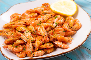 Shrimps with lemon on white plate