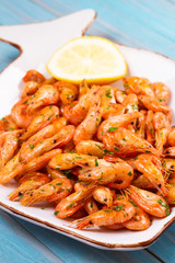 Shrimps with lemon on white plate