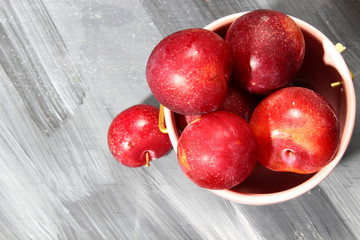 Overhead shot of Red Cherry plums on grey background