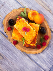 Cheesecake, garnished with berries, mint and peach. Sweet farmer cheese (cottage cheese) casserole