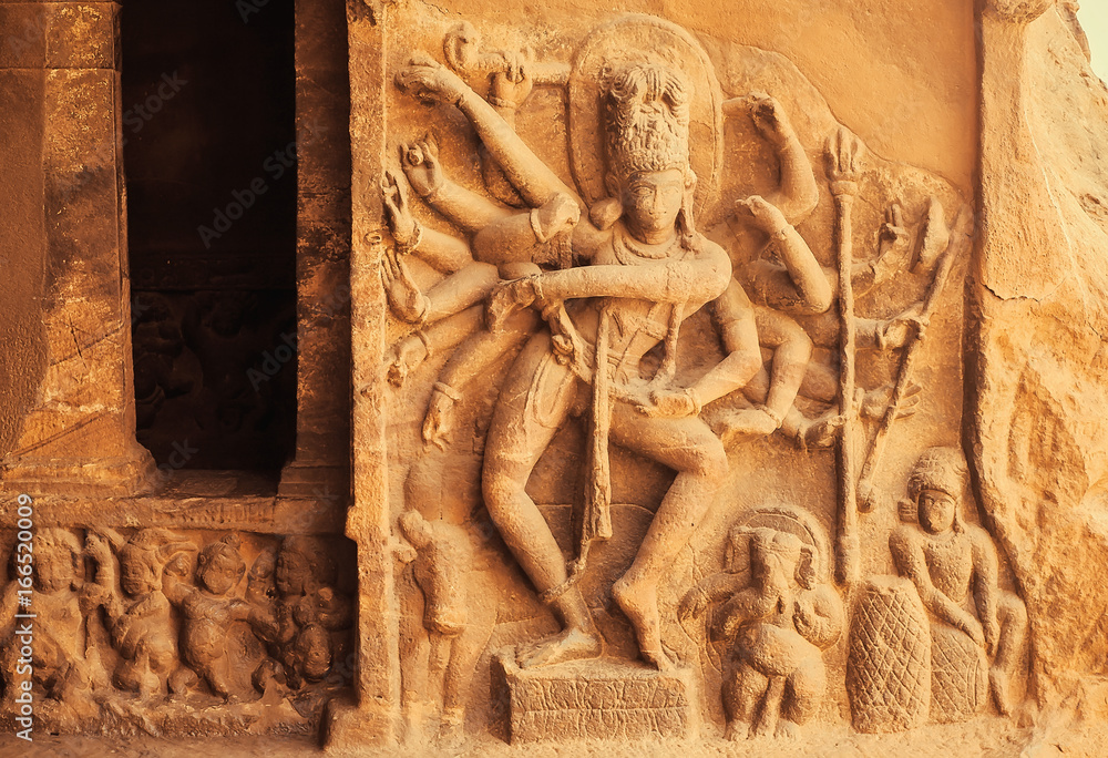 Wall mural Dance of Shiva Lord with many hands. Entrance to the Hindu temple with 6th century reliefs. Ancient Indian architecture