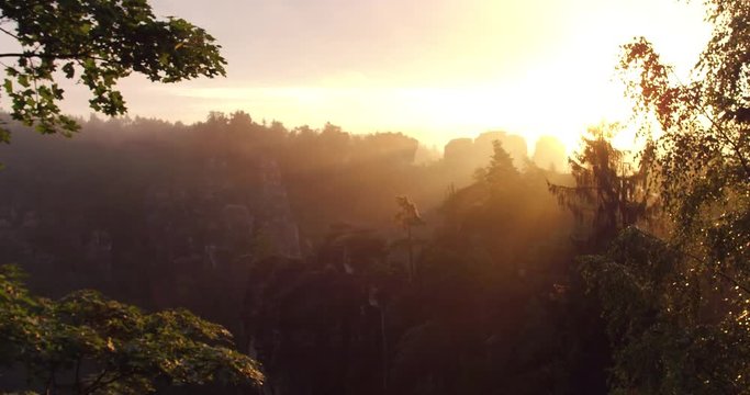 Drone view over the sandstone mountains in Saxon Switzerland, Germany - Aerial of beautiful forest landscape in romantic sunrise, 4K high quality scene  