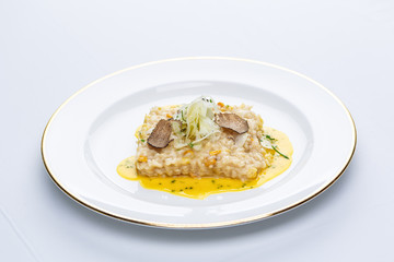 Risotto with truffles and corn sauce in white plate